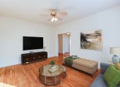 Thumbnail 6 of 23 - living area with sofa, coffee table, credenza, tv, hardwood floors and ceiling fan at chatham courts apartments in washington dc