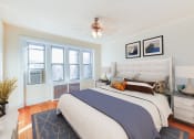 Thumbnail 9 of 23 - bedroom with bed, nightstand, hardwood floors, ceiling fan and large windows at chatham courts apartments in washington dc