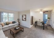 Thumbnail 2 of 15 - living area with sofa, coffee table, windows and view of dining area at manor village  tax credit apartments in washington dc