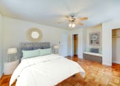 Thumbnail 7 of 15 - bedroom with bed, nightstands,  seating area, large closet, hardwood flooring and ceiling fan at new horizon apartments in washington dc