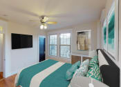Thumbnail 4 of 21 - bedroom with bed, dresser, large windows, ceiling fan and tv at the cortland apartments in washington dc
