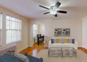 Thumbnail 4 of 12 - living area with sofa, coffee table, large window, ceiling fan and hardwood floors at 2801 pennsylvania apartments in washington dc