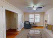 Thumbnail 5 of 12 - living area with sofa, coffee table, large window, ceiling fan and hardwood floors at 2801 pennsylvania apartments in washington dc