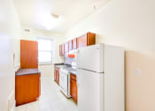 Thumbnail 4 of 23 - kitchen with tile flooring, white appliances and oak cabinetry at chatham courts apartments in washington dc