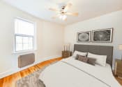 Thumbnail 6 of 26 - bedroom with bed, nightstand, ceiling fan and  large window at 2800 ontario road apartments in washington dc
