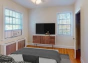 Thumbnail 7 of 27 - a bedroom with a bed and a television