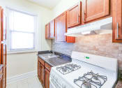 Thumbnail 1 of 23 - kitchen with tile backsplash, modern cabinetry, gas range and window at chatham courts apartments in washington dc
