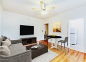 Thumbnail 1 of 15 - living area with sofa, coffee table, hardwood floors and view of kitchen at 1818 riggs apartments in washington dc