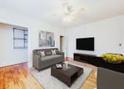 Thumbnail 2 of 15 - living area with sofa, coffee table, hardwood floors and ceiling fan at 1818 riggs apartments in washington dc