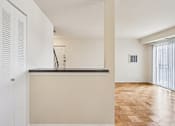Thumbnail 20 of 24 - A kitchen with a white counter and wooden floor.
