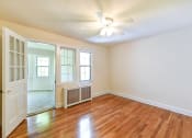 Thumbnail 20 of 27 - vacant bedroom with hardwood floors, ceiling fan, and doorway to sunroom den  at  2629 39th Street apartments in washington dc