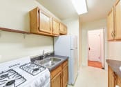 Thumbnail 10 of 27 - kitchen with tile flooring, wood cabinetry, energy efficient appliances and view to hallway at  2629 39th Street apartments in washington dc