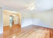 Thumbnail 11 of 27 - vacant living area with hardwood floors, celing fan and view of hallway and sunroom  at  2629 39th Street apartments in washington dc