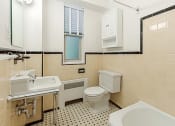 Thumbnail 11 of 40 - bathroom with toilet, tub, sink, window and large mirror at 2800 woodley road apartments in washington dc