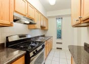 Thumbnail 10 of 40 - kitchen with stainless steel appliances and wood cabinetry at 2800 woodley road apartments in washington dc