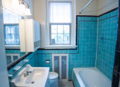Thumbnail 15 of 26 - bathroom with tub, vanity, large mirror, tile details and window  at 2800 ontario road apartments in washington dc