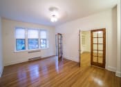 Thumbnail 12 of 26 - vacant living area with hardwood floors, french doors, large windows and ceiling fan at 2800 ontario road apartments in washington dc