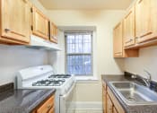 Thumbnail 20 of 26 - kitchen with tile flooring, white appliances and oak cabinetry at 2800 ontario road apartments in washington dc