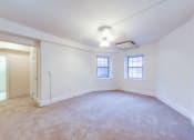 Thumbnail 21 of 26 - vacant living area with plush carpeting, large windows and ceiling fan at 2800 ontario road apartments in washington dc