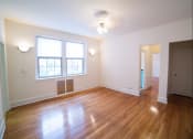 Thumbnail 11 of 26 - vacant living area with hardwood floors, large windows and ceiling fan at 2800 ontario road apartments in washington dc