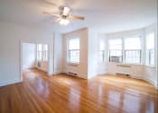 Thumbnail 9 of 26 - vacant living area with hardwood floors, large windows and ceiling fan at 2800 ontario road apartments in washington dc