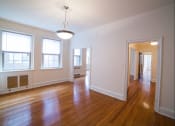 Thumbnail 18 of 26 - vacant living area with modern lighting, hardwood flooring, large windows and french doors at 2800 ontario road apartments in washington dc