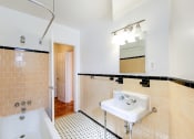 Thumbnail 19 of 40 - bathroom with tub, sink, mirror and tile details at 2800 woodley road apartments in woodley park washington dc