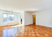 Thumbnail 14 of 40 - vacant living area with hardwood flooring and large window at 2800 woodley road apartments in woodley park washington dc