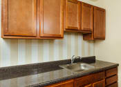 Thumbnail 1 of 12 - kitchen with wood cabinetry and tile backsplash at 2801 pennsylvania apartments in washington dc