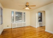 Thumbnail 7 of 12 - vacant living area with hardwood floors, large windows and ceiling fan at 2801 pennsylvania apartments in washington dc