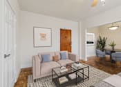 Thumbnail 5 of 28 - A living room with a couch, a coffee table, and a plant.