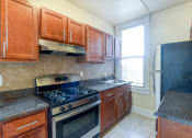Thumbnail 1 of 21 - kitchen with tile flooring, wood cabinetry, energy efficient appliances, gas range and window at the cortland apartments in washington dc