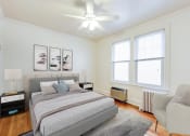 Thumbnail 12 of 17 - bedroom with bed, nightstands, sitting area, large windows and ceiling fan at 3213 wisconsin apartments in washington dc