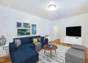 Thumbnail 7 of 17 - living area with sofa, coffee table, credenza, tv, hardwood flooring and modern artwork at 3213 wisconsin apartments in washington dc