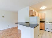 Thumbnail 19 of 39 - kitchen with wood cabinetry, gas range and breakfast bar at twin oaks apartments columbia heights washington dc