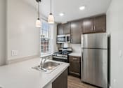 Thumbnail 4 of 32 - A modern kitchen with stainless steel appliances and wooden cabinets.