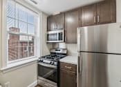 Thumbnail 3 of 32 - A kitchen with a stainless steel refrigerator, microwave, oven, and stove.