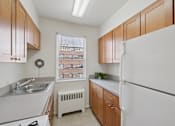 Thumbnail 5 of 23 - A kitchen with wooden cabinets and white appliances.