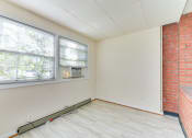 Thumbnail 13 of 16 - sunroom with exposed brick wall and woodlike flooring at 4020 calvert street apartments in washington dc