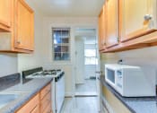 Thumbnail 1 of 16 - kitchen with gas range, wood cabinetry and energy efficient appliances at 4020 calvert street apartments in washington dc
