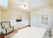 Thumbnail 14 of 18 - bedroom with bed, dresser, seating area and ceiling fan at 4031 davis place apartments in washington dc