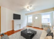 Thumbnail 10 of 18 - living area with sofa, coffee table, tv, large windows, hardwood floors and ceiling fan at 4031 davis place apartments in washington dc