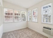 Thumbnail 10 of 17 - A room with a carpeted floor and a window with blinds.