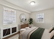 Thumbnail 4 of 24 - A bedroom with a bed, nightstand, and window with blinds.