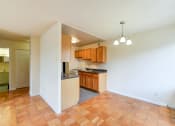 Thumbnail 25 of 39 - kitchen with wood cabinetry, gas range and view of dining area  at twin oaks apartments columbia heights washington dc