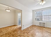 Thumbnail 18 of 28 - A room with a wooden floor and a ceiling fan.