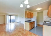 Thumbnail 26 of 39 - kitchen with wood cabinetry, gas range and view of living area at twin oaks apartments columbia heights washington dc