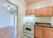 Thumbnail 3 of 39 - kitchen with wood cabinetry, gas range and view of living area  at twin oaks apartments columbia heights washington dc