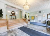 Thumbnail 29 of 29 - lobby lounge with social seating, ornate ceiling and stairs leading to elevators at the frontenac apartments in van ness washington dc