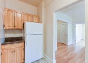 Thumbnail 5 of 39 - kitchen with wood cabinetry, refrigerator  and view of living area  at twin oaks apartments columbia heights washington dc